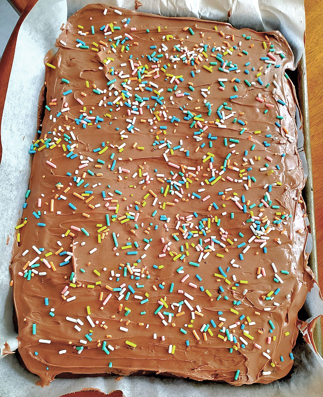 this is chocolate mayonnaise cake with sprinkles in sheet pan on parchment cake paper