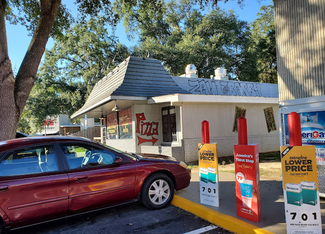 Pizza restaurant with Sing awning next to Tallahassee Sing Food Store & Deli #12