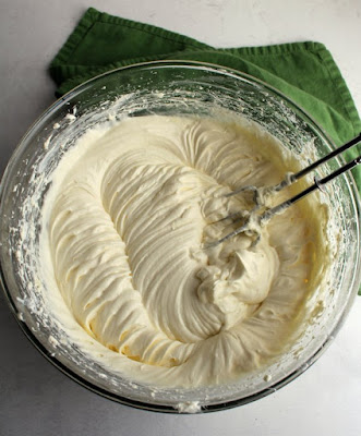 Dessert dips are such a great way to end a party. You can get a little something sweet without it being too much. This lemon cheesecake version is bright and delicious. Plus the texture is so silky there's the perfect amount of zing. It's so good! bowl of freshly whipped lemon dip with mixer beaters