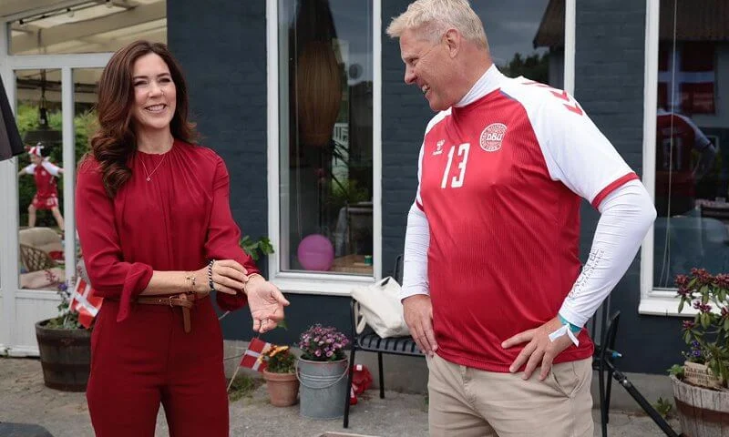 Crown Princess Mary wore a banora red gathered silk blouse from Hugo Boss, and ivory white cashmere coat from Boss. Denmark and Finland