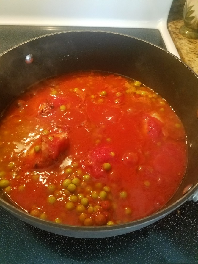 This is a rich tomato sauce with peas and chicken parts in it