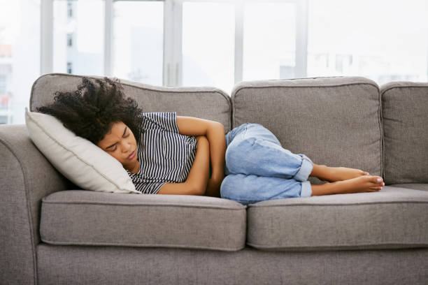 woman suffering from menstrual cramps on the sofa