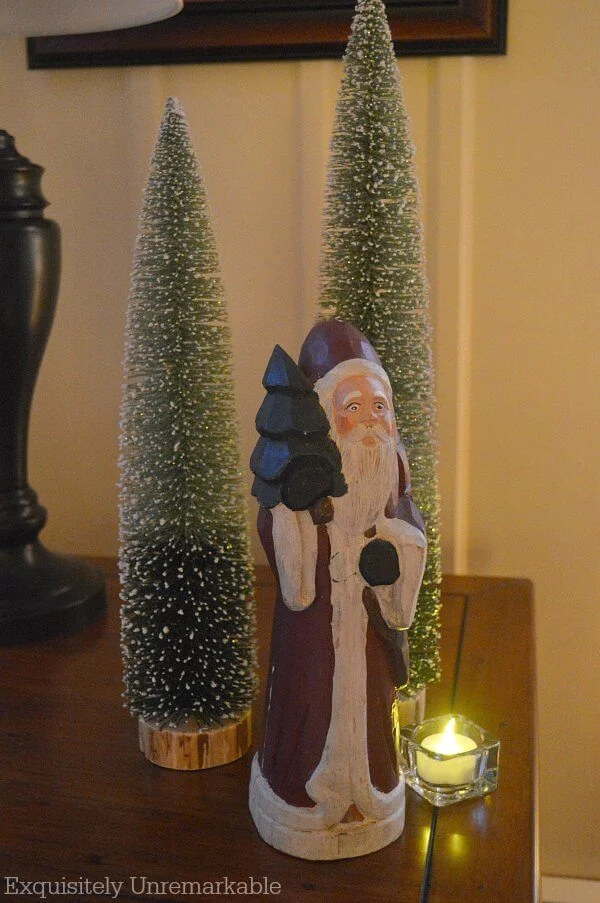 Bottle Brush Trees on a table with Santa statue and votive candle