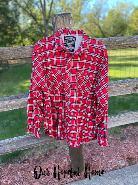 Nautica jeans Co. red plaid flannel shirt hanging on fence