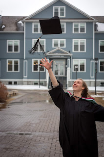 a young woman in graduation cap and gown tosses her hat in the air