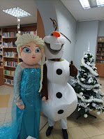 Elza i Olaf pozujący do zdjęcia przy choince w Czytelni Biblioteki.