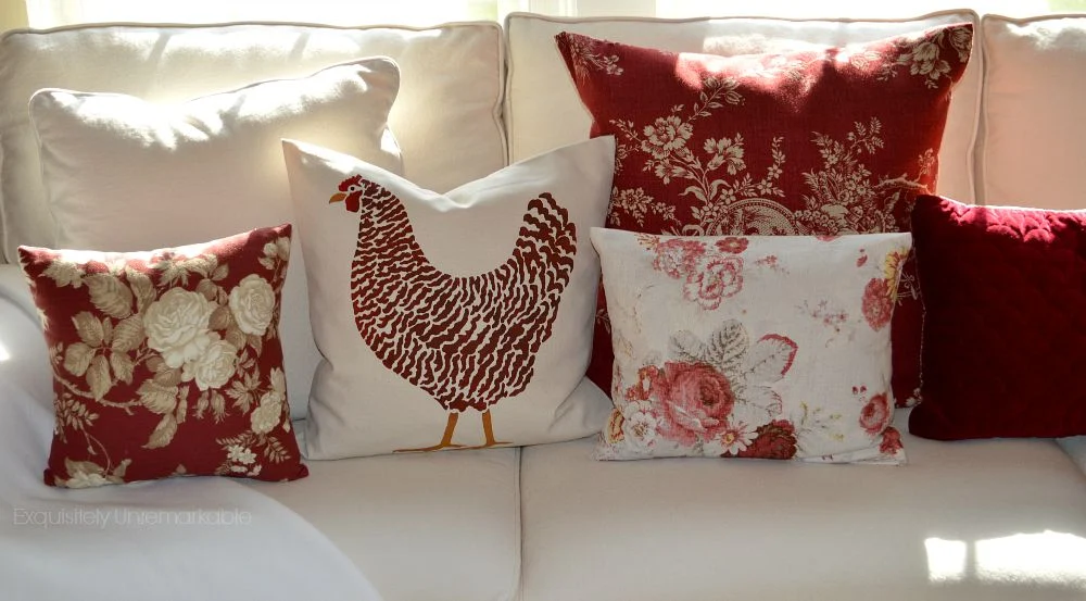 White couch with floral and chicken pillows