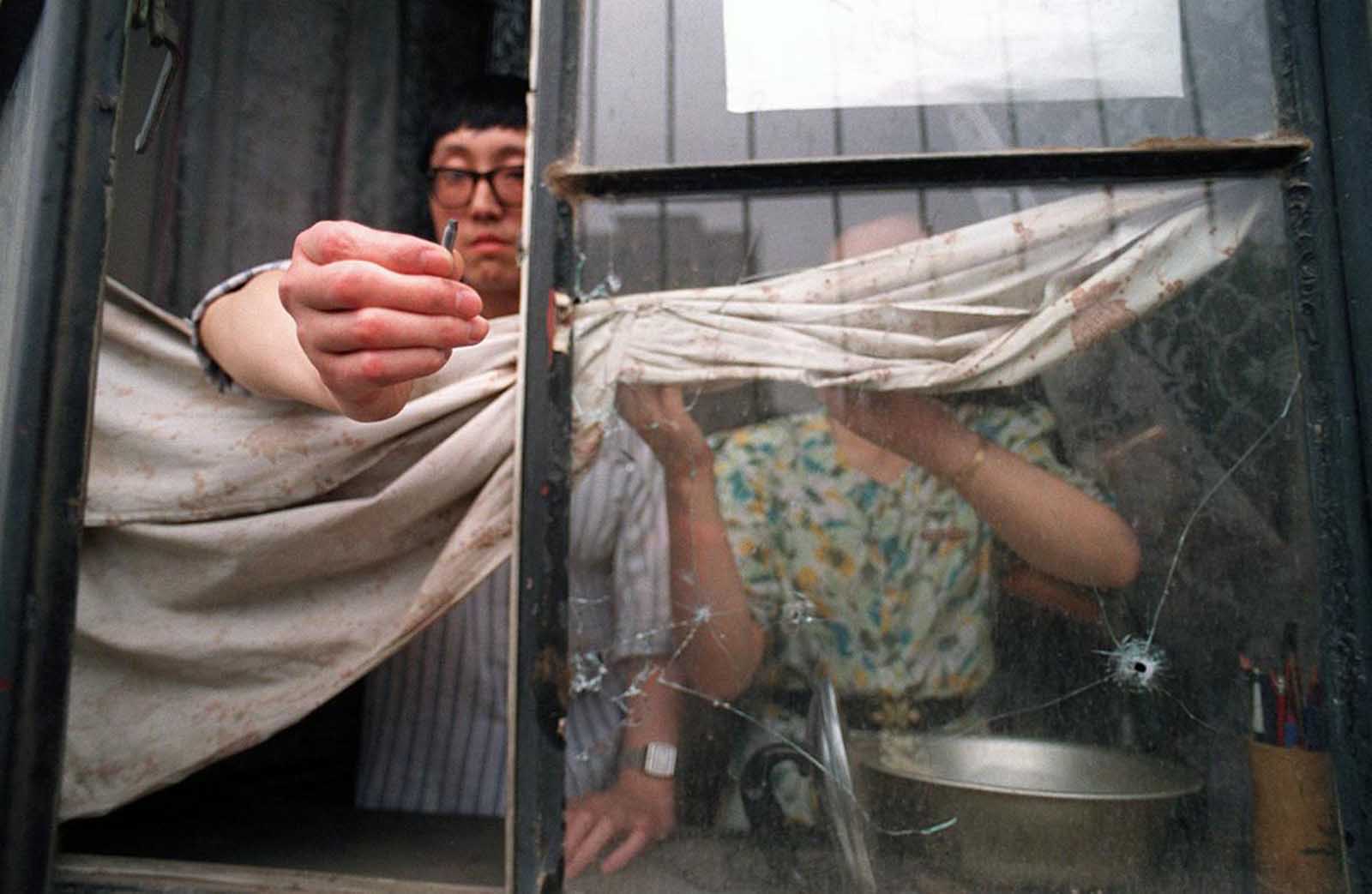 A Beijing resident on the west side of Tiananmen Square shows a slug from the automatic rifle fired by the army that went through his flat's window in central Beijing.