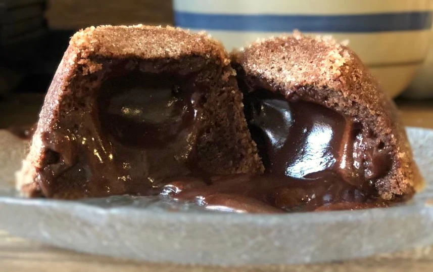 Easy chocolate lave cake serve on a plate with oozing chocolate center.