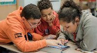 3 students looking at a tablet