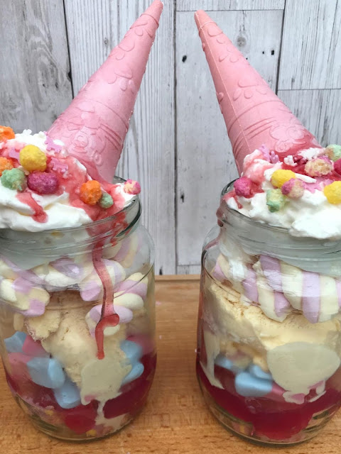 Unicorn sundaes made with sweets and ice cream and a pink cone for a horn