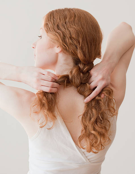 woman braiding her curly hair