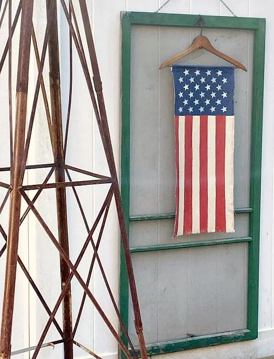 Vertical American flag hanging on a vintage green screen door