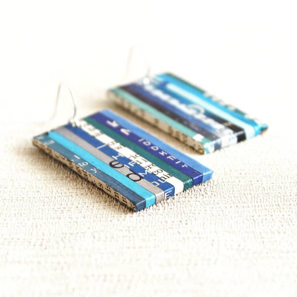 rechthoekig paar oorbellen bestaande uit papieren stroken met patroon in blauwtinten