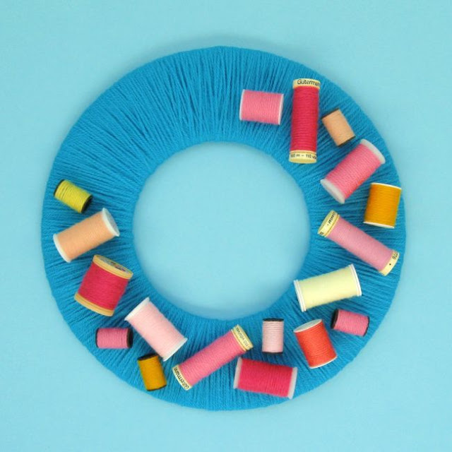 DIY Upcycled Sewing Thread Reels Wreath Tutorial Yarn-wrapped wreath decorated with colourful upcycled sewing thread reels