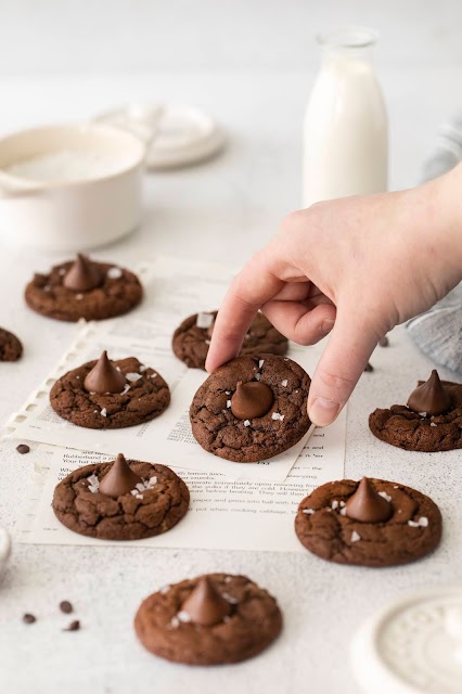 cookies on cookbook pages with a hand holding one.