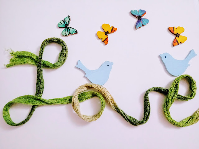 Love en cinta de malla verde con mariposas y pajaritos de madera