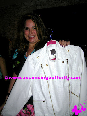 Aimee Cheshire CEO of Madison Plus holds up a White Jacket from MYNT 1792 at Madison Plus Select Press Preview Event at Alison Eighteen in New York City