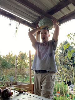 Farmer man with Blue Hubbard Squash lifted over his head