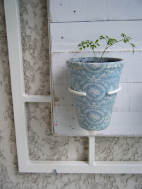 Um vaso decorado com tecido encaixado numa argola