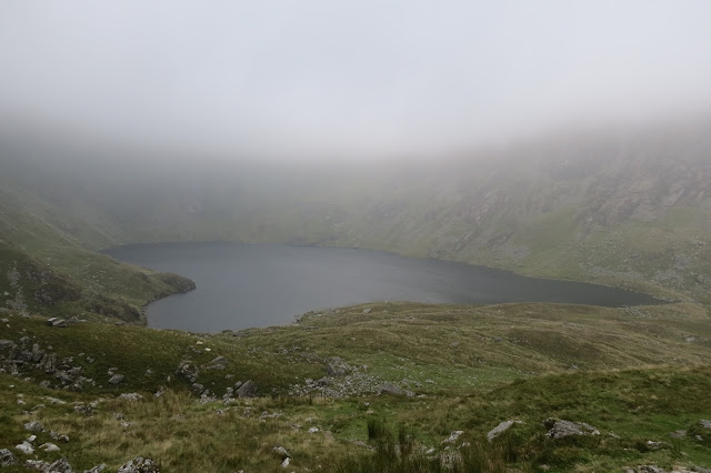 A fuller view of the lake with mist and cloud suspended above it.