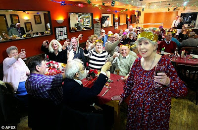 Betty Williams standing with the guests at christmas lunch