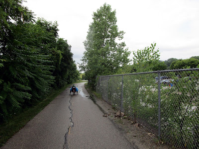 Sister rides trike on trail.