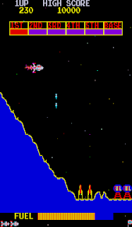Captura de pantalla de Scramble. La imagen muestra a todo color nuestra nave en forma de cohete disparando a otras naves que ascienden y a depósitos de "fuel" en desplazamiento horizontal