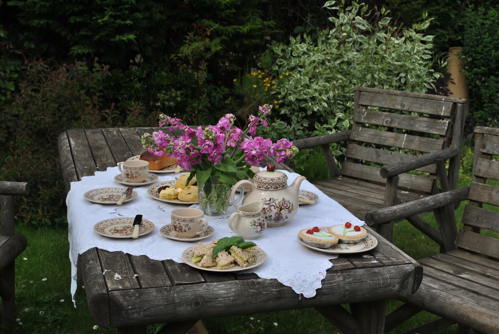 чаепитие в весеннем саду. завтрак на природе. летний завтрак в саду. завтрак в саду. стол в саду.