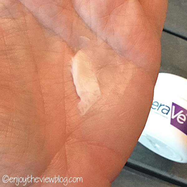 CeraVe Skin Renewing Night Cream on the palm of a hand with the product jar in the background