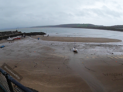 Visão mais ampla da praia com alguns mergulhadores no País de Gales
