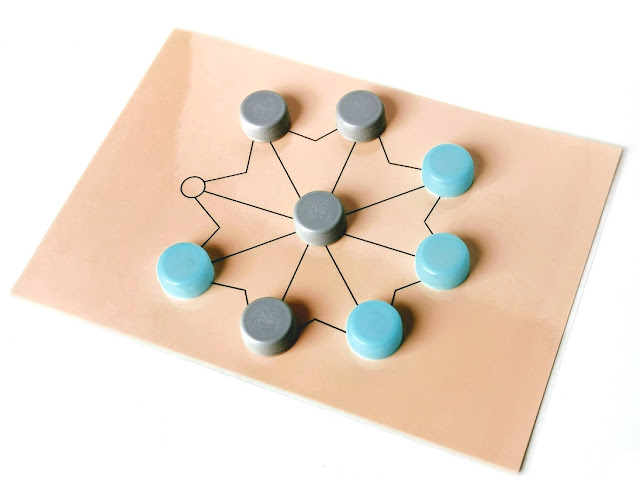 mu torere abstrakcyjne strategiczne gry planszowe zasady na zdjęciu plansza do gry i układ pionków w trakcie rozgrywki