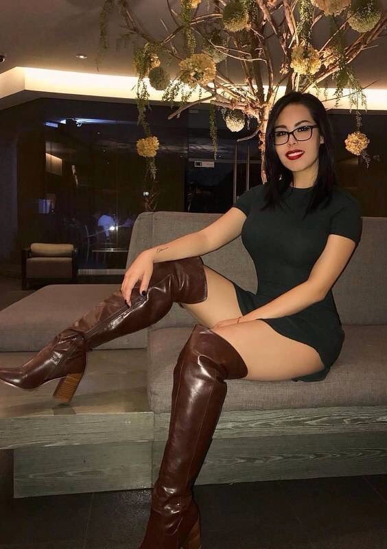 Elegant seated woman showing off her legs in boots