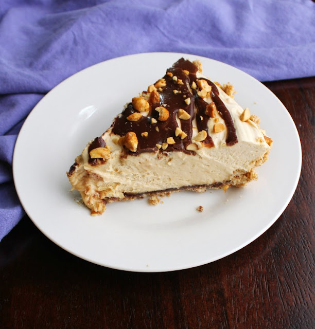 This peanut butter pie has it all; a pretzel crust coated with a layer of chocolate filled with creamy peanut butter goodness. There is no whipped topping in site, but it is still super easy to make! slice of creamy no bake peanut butter pie with drizzle of fudge and chopped peanuts on top