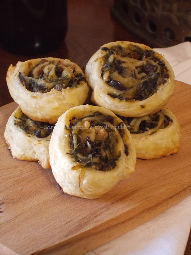 Girelle di pasta sfoglia con indivia scarola, uvetta, olive, capperi e pinoli