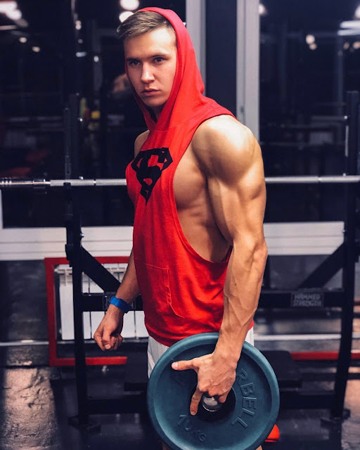 Aleksey Teterin wearing a sleeveless, deep-cup Superman hoodie in the gym