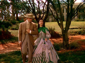 Clark Gable as Rhett Butler and Vivien Leigh as Scarlet O'Hara walking outside Tara in Gone with the Wind movieloversreviews.filminspector.com