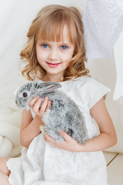 A girl holding a rabbit representing how maladaptive daydreaming affects childhood.