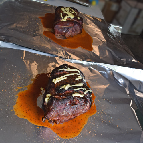 Wrapping the pork butts with rub, butter, and Stubbs Mop