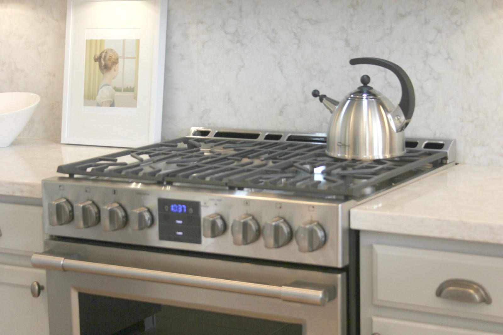 Serene chic simple Nordic French kitchen with grey cabinets and Soprano quartz countertop and backsplash