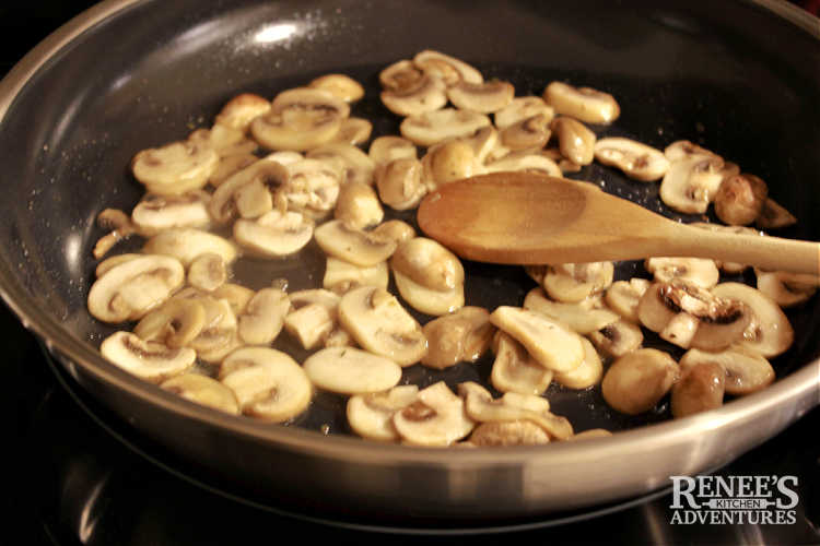 Mushrooms and shallots sautee in a skillet on stove for mushroom gravy