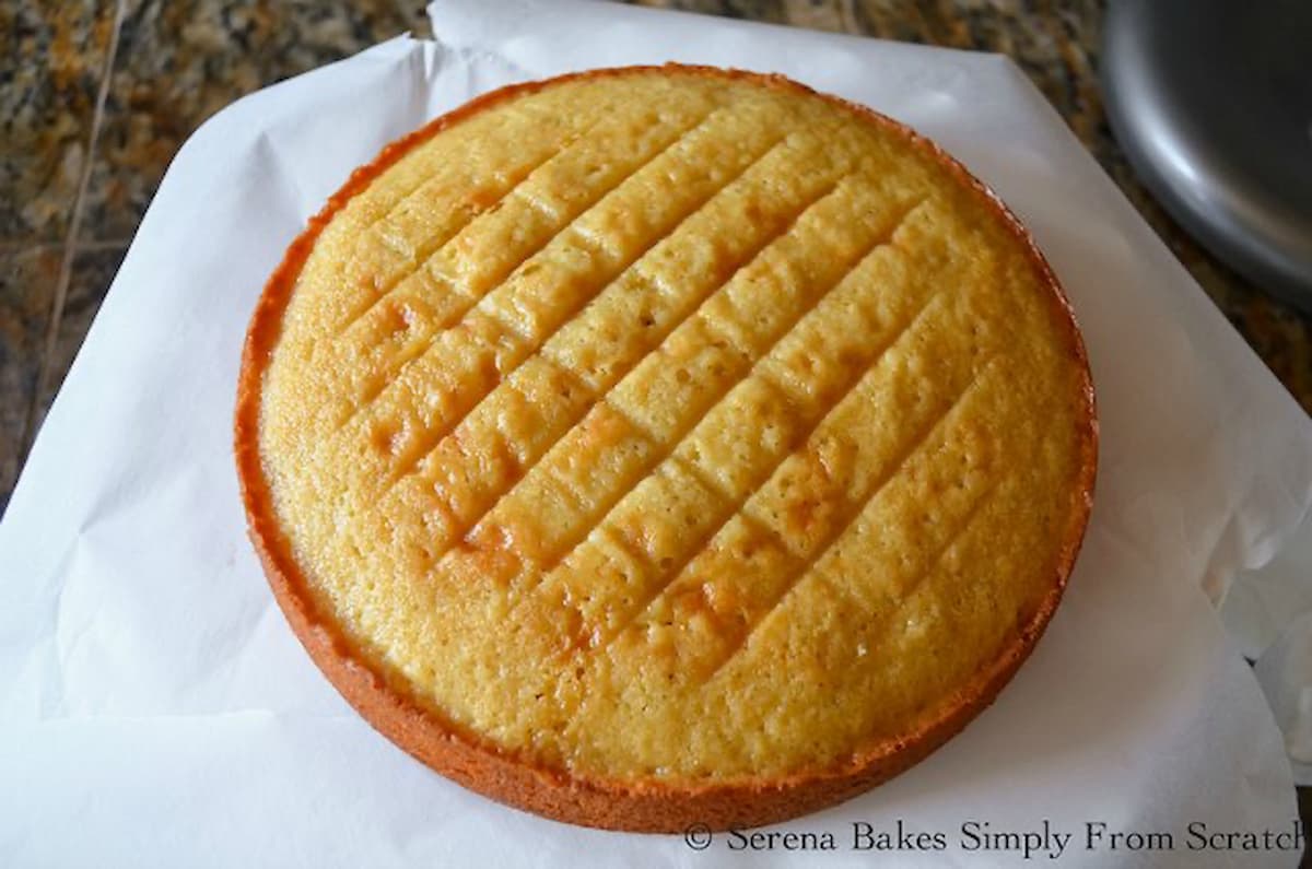 Yellow Cake taken out of pan sitting on parchment paper.