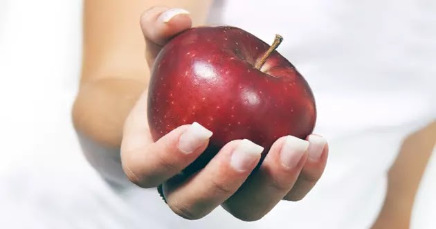 معلومة عن التفاح يد تقدم تفاحة