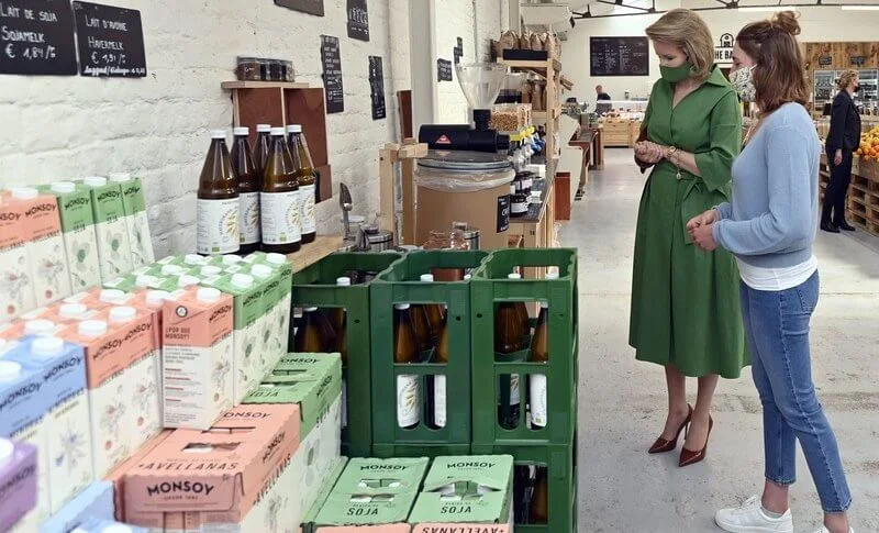 Queen Mathilde wore a green belted shirt dress from Natan, and she carries Fabienne Delvigne cluth bag