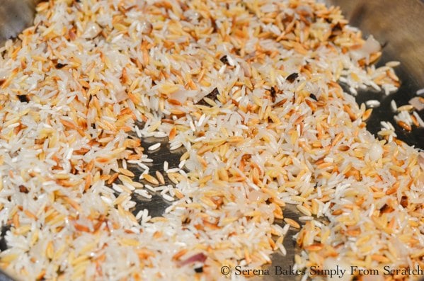Jasmine rice stirred into brown orzo in a large sauté pan.
