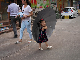 little girl smiling and holding a large umbrella in Zhuhai, China