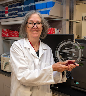 Dr. Kathleen Pratt holds up an award