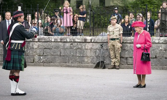 The Queen wore a raspberry pink coat and a matching hat, with a floral dress