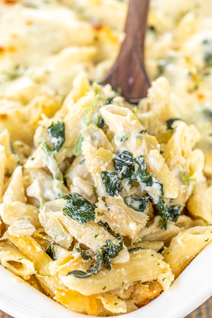 Three Cheese Chicken Spinach & Artichoke Alfredo Pasta - think cheesy chicken Alfredo pasta meets spinach & artichoke dip. Two of my all-time favorites in one pan. Super easy to make. Can freeze for a quick meal later!! Penne pasta, Alfredo sauce, ricotta cheese, sour cream, garlic, parmesan cheese, frozen spinach, chopped artichokes, eggs, and chopped chicken. Use a rotisserie chicken for quick prep. Makes a ton - great for a crowd! #pasta #chicken #spinach #artichokes #casserole #freezermeal spoonful of chicken and spinach pasta