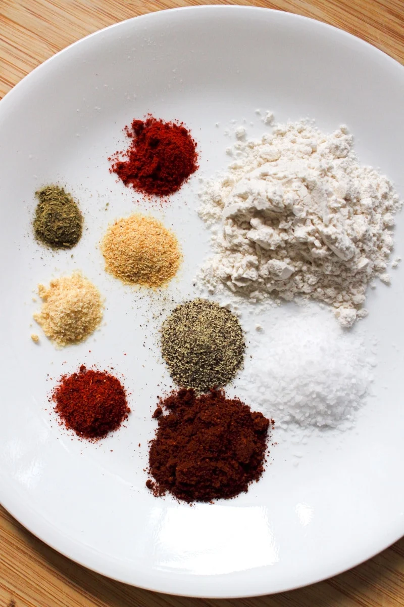 Spices used in making Air Fryer Breaded Chicken Wings on a white plate.